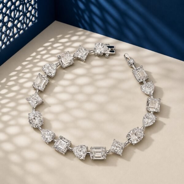 A high-end macro photo of a mixed shape lab diamond tennis bracelet with emerald, pear, and heart-cut stones titled Tennis Bracelet