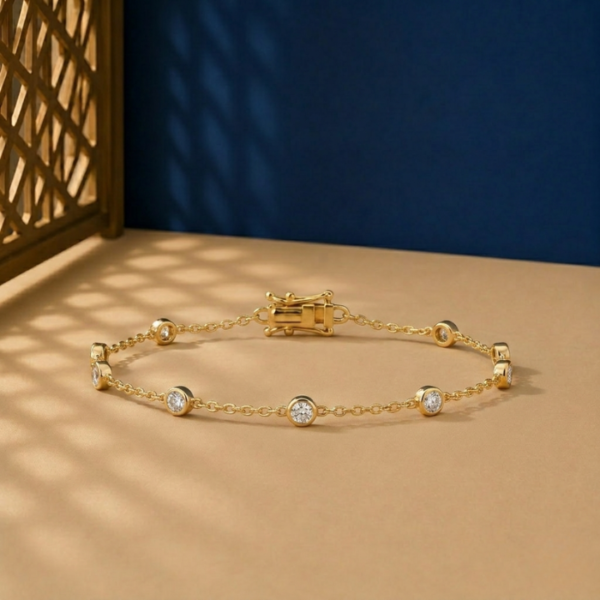 Bezel set lab diamond station bracelet on a yellow gold link chain.