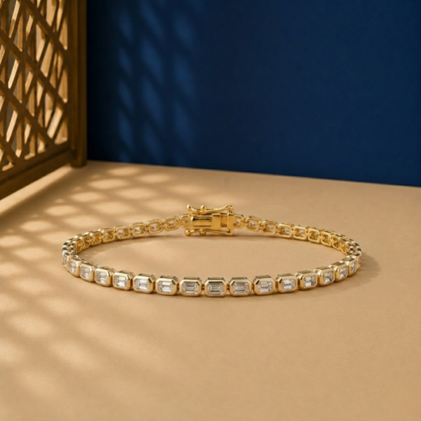 Bezel set emerald cut lab diamond bracelet in yellow gold with an east-west stone orientation.