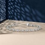 Flora design lab-grown diamond tennis bracelet shown on a split blue and cream background.