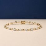Luminous marquis link lab-grown diamond bracelet shown in a yellow-toned metal on a textured neutral surface.