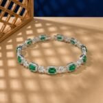 Emerald and lab diamond bracelet with emerald-cut green stones and marquise diamond clusters.