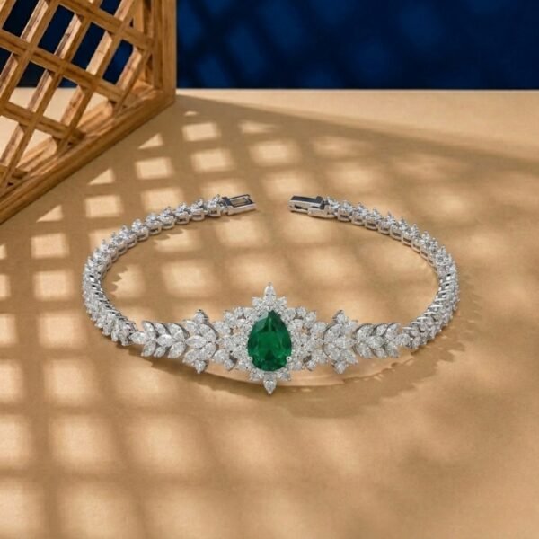 Pear-cut lab emerald statement bracelet with marquise diamond floral clusters in white metal.