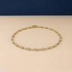 Round brilliant lab diamond station bracelet in yellow metal links.