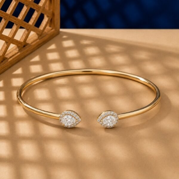 Pear-cut lab diamond open cuff bangle with diamond halos in yellow gold.