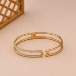 Yellow gold arrow cuff bangle with two rows of lab diamonds and a hinged opening.