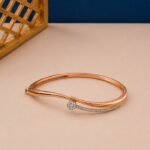 Rose gold bypass bangle with a lab diamond cluster and pavé-set diamond trail.