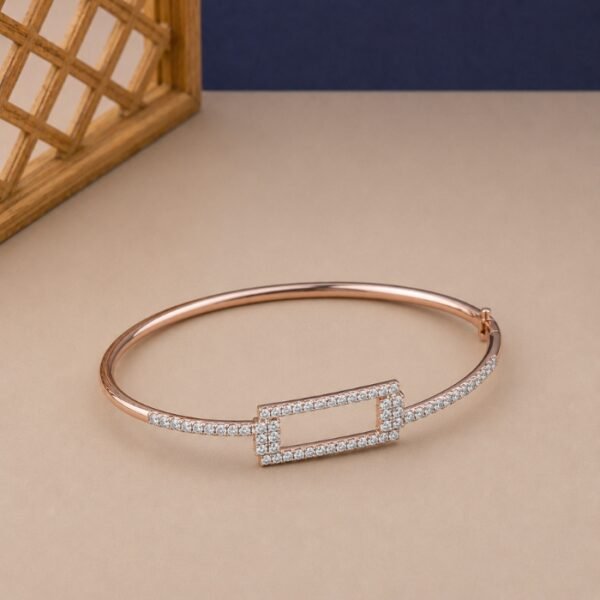 Rose gold geometric bangle with a rectangular lab diamond frame and pavé shoulders.