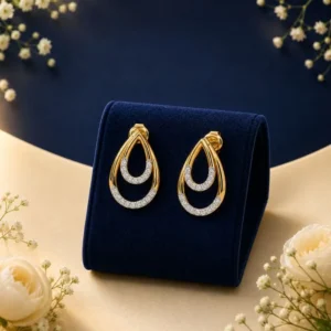 Pair of 18K yellow gold double layered teardrop earrings encrusted with rows of pave lab-grown diamonds, displayed on a navy blue velvet mount.