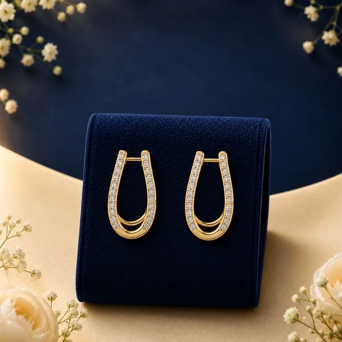 Elysian U-Shaped Lab-Diamond Huggie Hoops A pair of 18K yellow gold U-shaped elongated huggie hoop earrings featuring a pave row of lab-grown diamonds, displayed on a navy blue velvet background.