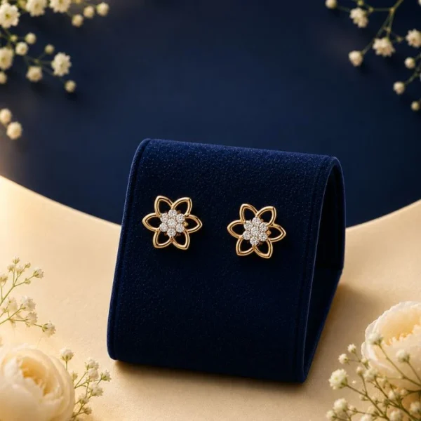 Pair of 18K yellow gold six-petal flower openwork stud earrings featuring a center cluster of sparkling lab-grown diamonds, displayed on a blue velvet stand.