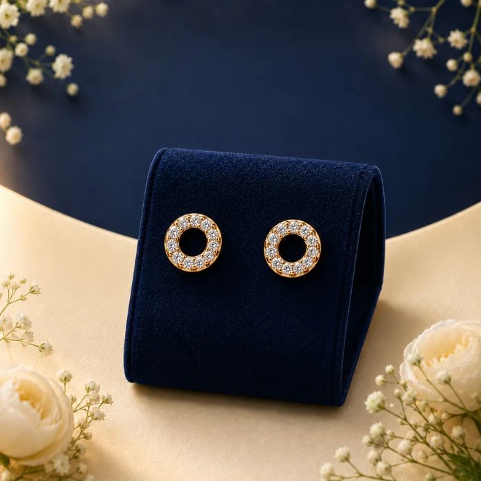 Aura Open Circle Lab-Diamond Eternity Studs Pair of 18K yellow gold open circle stud earrings featuring a continuous eternity loop of pave white lab-grown diamonds, displayed on a blue velvet mount.