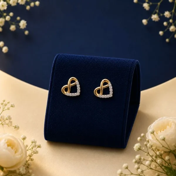 Pair of 18K yellow gold four-point star stud earrings featuring a brilliant round-cut white lab-grown diamond at the center, displayed on a blue velvet mount.