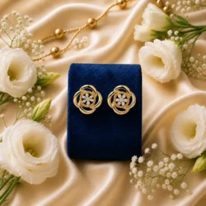 Gold floral stud earrings with lab grown diamonds on a blue velvet box