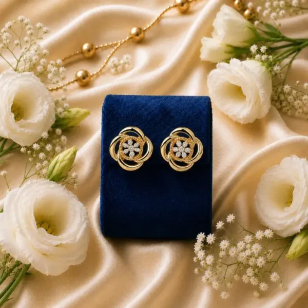 Gold floral stud earrings with lab grown diamonds on a blue velvet box