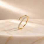 Open wrap lab diamond pavé ring in yellow gold with bezel-set round diamond accent