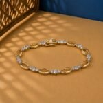 Oval Link Lab Diamond Bracelet featuring alternating polished gold ovals and diamond clusters on a tan background.