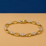 Oval Link Lab Diamond Bracelet featuring alternating polished gold ovals and diamond clusters on a tan background.