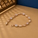 Pear Cut Lab Diamond Lattice Bracelet featuring alternating pear-cut diamond halos and rose gold lattice links on a tan background.