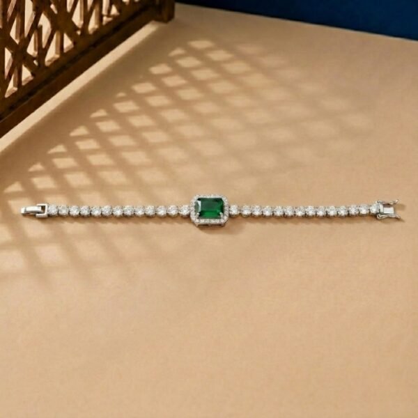 Emerald Halo Lab Diamond Bracelet featuring a green emerald-cut center stone with a diamond halo on a tan background