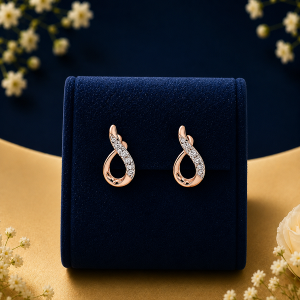 Rose gold infinity lab grown diamond huggie earrings on blue velvet box