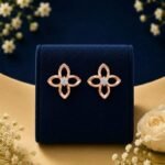 14k gold flower diamond studs featuring a 4-petal open motif with a central diamond cluster, displayed on a blue velvet stand.