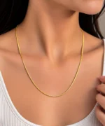 Woman wearing a luxury 18K yellow gold chain with a sleek minimal design
