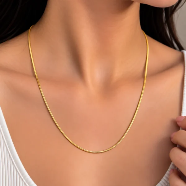 Woman wearing a luxury 18K yellow gold chain with a sleek minimal design