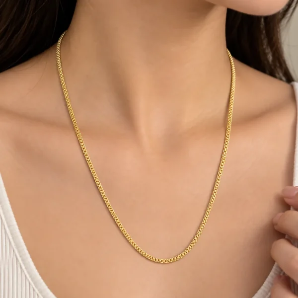 Woman wearing an elegant 18K yellow gold chain with a refined woven-style link design
