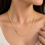 Woman wearing a luxury 18K yellow gold chain with a sleek geometric link design