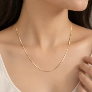 Woman wearing a classic 18K yellow gold box chain with a sleek minimal design