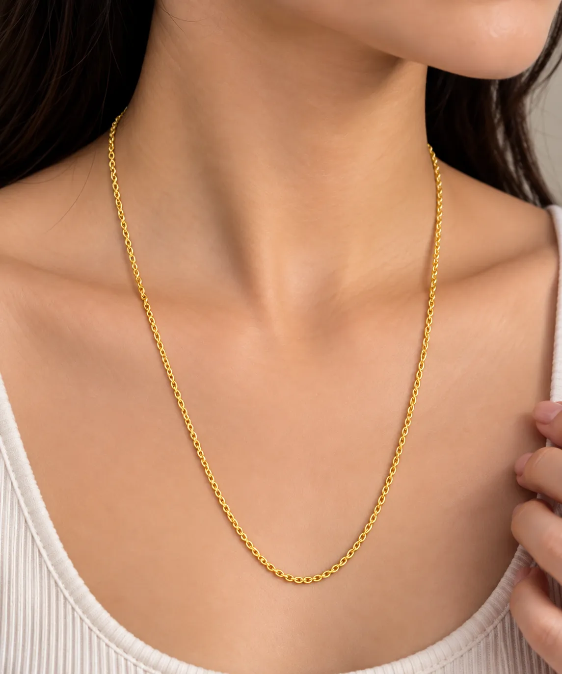 Woman wearing a classic 18K yellow gold chain with a delicate rounded interlinked design