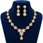 18K Gold Halo Lab Grown Diamond Necklace Set with Matching Earrings featuring sparkling round halo diamond designs, elegant teardrop pendant and premium yellow gold finish displayed on a navy blue jewellery stand.