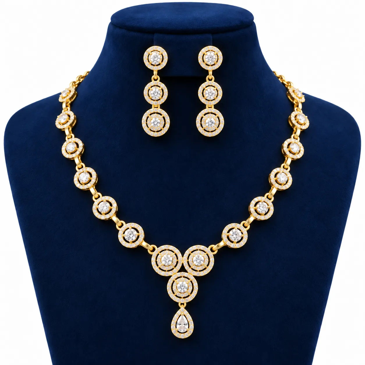 18K Gold Halo Lab Grown Diamond Necklace Set with Matching Earrings (5) - Copy 18K Gold Halo Lab Grown Diamond Necklace Set with Matching Earrings featuring sparkling round halo diamond designs, elegant teardrop pendant and premium yellow gold finish displayed on a navy blue jewellery stand.