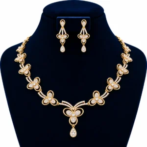 18K gold lab grown diamond floral necklace set with three-petal diamond flowers, central teardrop pendant and matching drop earrings on navy blue jewellery bust