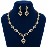 18K Gold Leaf Design Lab Grown Diamond Necklace Set with Matching Earrings featuring sparkling diamond-studded leaf motifs, floral centre and elegant drop pendant displayed on a navy blue jewellery stand.