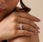 Bow Moissanite 925 Sterling Silver Ring worn on a woman's finger with elegant round solitaire and sparkling side stones.