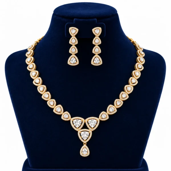 18K gold trillion cut lab grown diamond halo necklace set with triangular diamond motifs, central dangling pendant and matching earrings on navy blue jewellery bust