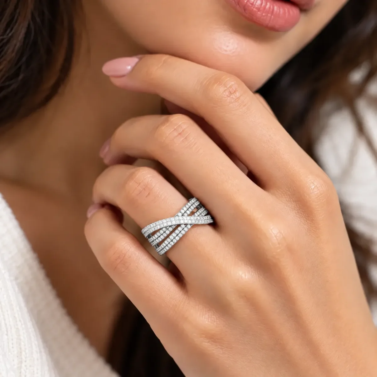 Woman wearing Infinity Moissanite Diamond Ring in 925 Sterling Silver with sparkling crisscross bands on her ring finger.