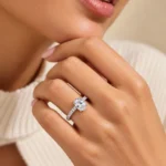 Olivia oval solitaire moissanite diamond ring in 925 sterling silver worn on a woman's ring finger.