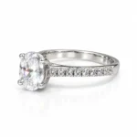 Left side view of Olivia oval moissanite diamond ring featuring a four-prong setting and pavé 925 silver band.