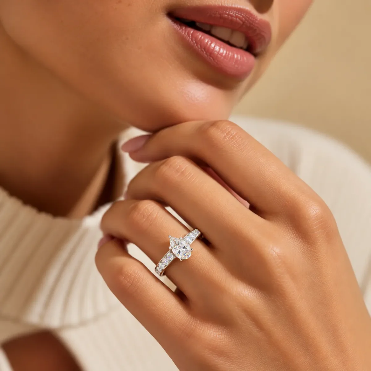 Woman wearing Pear Cut Moissanite Diamond Ring in 925 Sterling Silver with sparkling side stones and elegant silver band.