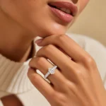 Woman wearing Pear Cut Moissanite Diamond Ring in 925 Sterling Silver with sparkling side stones and elegant silver band.