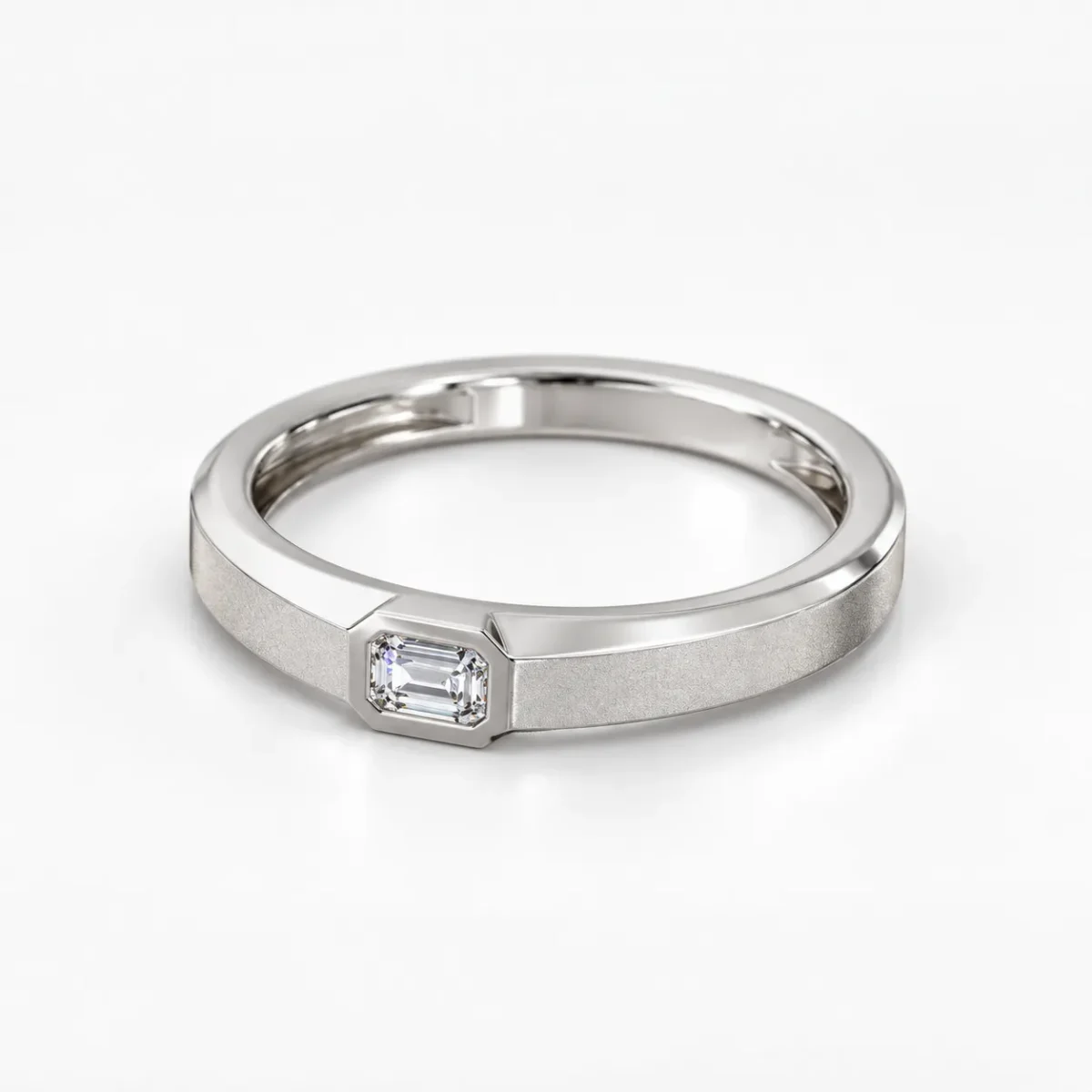 Angled view of Regal Emerald Moissanite Men's Ring showcasing a silver band, emerald-cut Moissanite gemstone and textured finish.